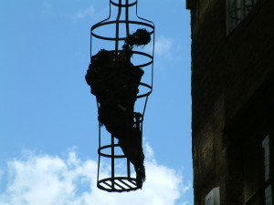 Prisoner in the overhead cage outside the Clink.